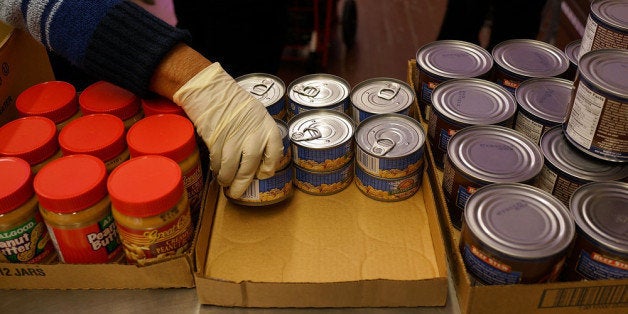 NEW YORK, NY - FEBRUARY 18: A volunteer distributes food at CAMBA's Beyond Hunger Emergency Food Pantry on February 18, 2014