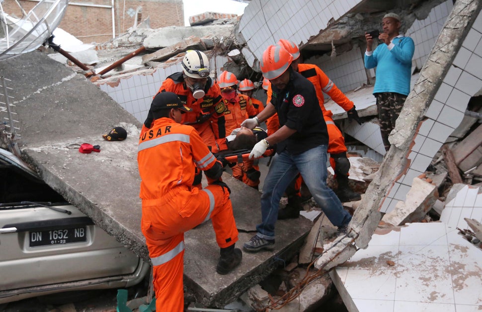 Rescuers pulled a survivor from a building damaged by a massive earthquake in Palu.<i></i><i></i>
