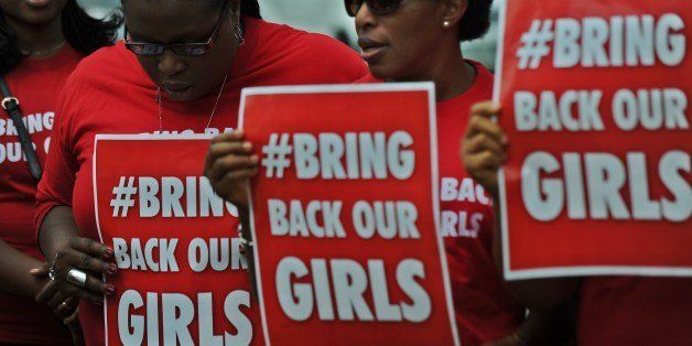 Nigerian women living in Kenya demonstrate to press for the release of Nigerian school girls kidnapped in nothern Nigeria by members of the Boko Haram, on May 16, 2014 in Nairobi. The '#bringbackourgirls' slogan has become a huge global phenomenon following the abductions, albeit controversial, as world and opinion leaders get involved under its banner on social media to aggitate for the release of the girl-students by the islamist militants who continued their rampage by razing two schools in Bauchi state, northern Nigeria, where Boko Haram gunmen previously attacked a girls' school. AFP PHOTO/Tony KARUMBA (Photo credit should read TONY KARUMBA/AFP/Getty Images)