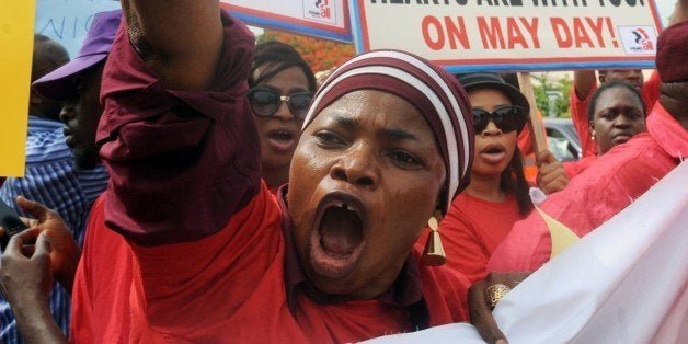 Members of civil society groups hold placards and shout slogans as they protest the abduction of Chibok school girls during a rally pressing for the girls' release in Abuja on May 6, 2014, ahead of World Economic Forum. Members of civil society groups marched through the streets of Abuja and to the Nigerian defence headquarters to meet with military chiefs, to press for the release of more than 200 Chibok school girls abducted three weeks ago. Suspected Boko Haram Islamists have kidnapped eight more girls from Nigeria's embattled northeast, residents said on May 6, after the extremist group's leader claimed responsibility for abducting more than 200 schoolgirls last month and said in a video he was holding them as 'slaves' and threatened to 'sell them in the market'. AFP PHOTO/PIUS UTOMI EKPEI (Photo credit should read PIUS UTOMI EKPEI/AFP/Getty Images)