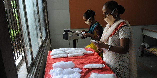 Members of Self Employed Women's Association (SEWA) make low cost sanitary pads at their facility in Ahmedabad on September 3, 2012. Prompted by the widespread suffering of women and girls in rural areas who continue to be plagued by unhygienic old cloth pieces or rags during their menstrual cycle periods, SEWA has began manufacturing low cost sanitary pads with the current production capacity at 2,000 pads per day. The price of each sanitary pad will be about one Indian rupee. AFP PHOTO / Sam PANTHAKY (Photo credit should read SAM PANTHAKY/AFP/GettyImages)