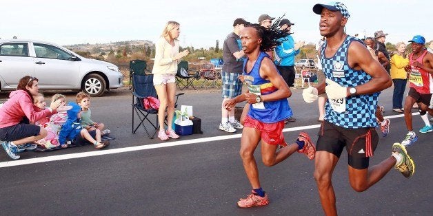 Spectators cheer runners as close to 16, 000 competitors from South Africa and abroad run the 89,2 kilometres ultra distance Comrades Marathon from Pietermaritzburg to Durban on June 1, 2014.AFP /PHOTO RAJESH JANTILAL (Photo credit should read RAJESH JANTILAL/AFP/Getty Images)