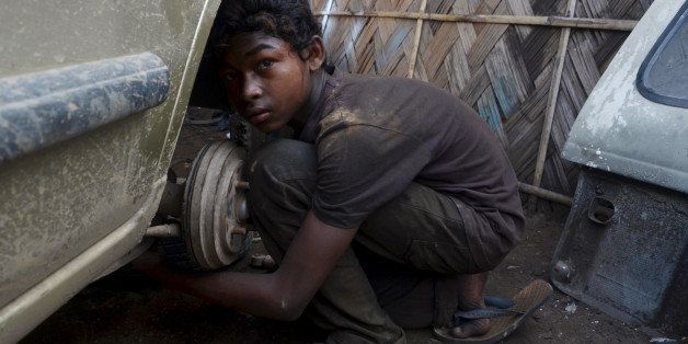 Ural Rahul, 15, works on a car at a repair garage in Dimapur, India's northeastern state of Nagaland, on June 12, 2013, the World Day Against Child Labour. The day, first observed in 2002 and sanctioned by the International Labour Organization (ILO), aims to highlight the plight of children engaged in work that deprives them of adequate education, health, leisure and basic freedoms, violating their rights. AFP PHOTO/CAISII MAO (Photo credit should read Caisii Mao/AFP/Getty Images)