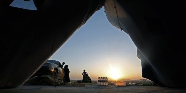 Iraqi families gather at a temporary camp set up to house civilians fleeing violence, in Iraq's northern Nineveh province, in