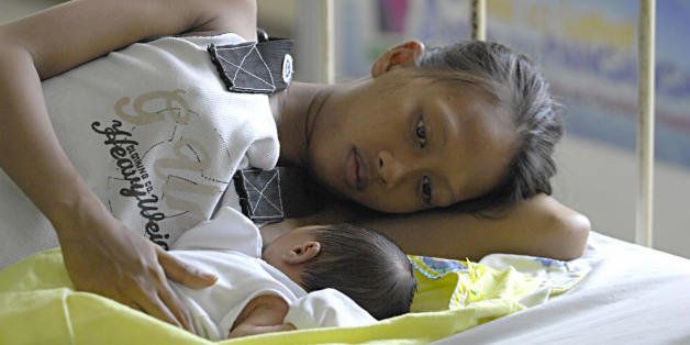 A mother breastfeeds her new born baby inside a maternity clinic in Manila on May 15, 2009. A UN official on May 15 urged the Philippines to do more to reduce the large numbers of its women who die from complications from pregnancy and childbirth. United Nations Children's Fund (UNICEF) data shows a Filipina mother has a one in 140 chance of dying while delivering a child, which translates to around 11 mothers dying everyday or 4,500 every year. AFP PHOTO / JAIME RIUS (Photo credit should read JAIME RIUS/AFP/Getty Images)