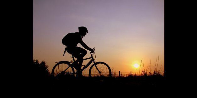 Cycling on bike through Lake District at sunset.