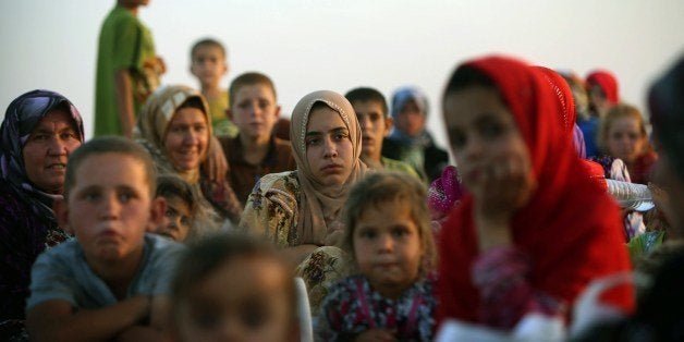 Iraqi families fleeing violence in the northern city of Tal Afar, arrive at the Kurdish checkpoint in Aski kalak, 40 km West of Arbil, in the autonomous Kurdistan region, on July 1, 2014. Saudi Arabia pledged $500 million in humanitarian aid for Iraq to be disbursed through the United Nations to those in need regardless of sect or ethnicity, state media reported. AFP PHOTO/SAFIN HAMED (Photo credit should read SAFIN HAMED/AFP/Getty Images)