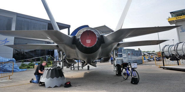 A staff member prepares the replica of Lockheed Martin F-35 fighter jet at the exhibition centre ahead of the Singapore's Airshow on February 9, 2014. Asia's top aerospace and defence show opens on February 11 in Singapore with major global arms makers seeking to cash in on rising military spending as territorial disputes escalate in the region. AFP PHOTO / ROSLAN RAHMAN (Photo credit should read ROSLAN RAHMAN/AFP/Getty Images)