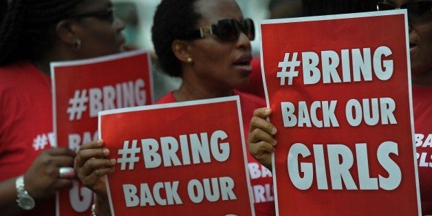 Nigerian women living in Kenya demonstrate to press for the release of Nigerian school girls kidnapped in nothern Nigeria by members of the Boko Haram, on May 16, 2014 in Nairobi. The '#bringbackourgirls' slogan has become a huge global phenomenon following the abductions, albeit controversial, as world and opinion leaders get involved under its banner on social media to aggitate for the release of the girl-students by the islamist militants who continued their rampage by razing two schools in Bauchi state, northern Nigeria, where Boko Haram gunmen previously attacked a girls' school. AFP PHOTO/Tony KARUMBA (Photo credit should read TONY KARUMBA/AFP/Getty Images)