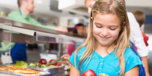 Happy little girl making healthy choices in school cafeteria