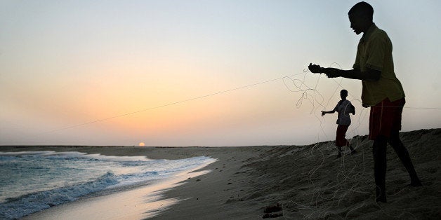 Photo made January 4, 2010 shows young Somali boys drawing their fishing lines at the coastal town of Hobyo in northeastern Somalia near where Greek cargo ship, MV Filitsa, is anchored since it was captured November 10, 2009. Hefty ransoms paid to pirates for the release of ships and crews has residents of the small town, including children abandoning their traditional lifestyle of fishing and attending school and scrambling to join pirate-gangs. The Marshall Islands-flagged ship with its crew of 22, including three Greek officers and 19 Filipinos was captured some 513 nautical miles north-east of the Seychelles as it was sailing from Kuwait to Durban in South Africa loaded with fertilizer. AFP PHOTO/ MOHAMED DAHIR (Photo credit should read MOHAMED DAHIR/AFP/Getty Images)