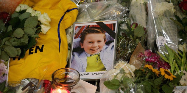 AMSTERDAM, NETHERLANDS - JULY 20: A photograph of a young boy lies amongst tributes at the entrance to Schiphol Airport which has grown into a sea of flowers in memory of the victims of Malaysia Airlines flight MH17 on July 20, 2014 in Amsterdam, Netherlands. Malaysian Airlines flight MH17 was travelling from Amsterdam to Kuala Lumpur when it crashed killing all 298 on board including 80 children. The aircraft was allegedly shot down by a missile and investigations continue over the perpetrators of the attack. (Photo by Christopher Furlong/Getty Images)