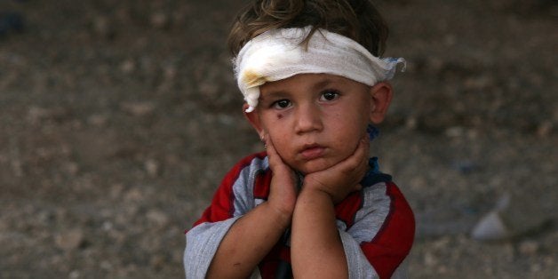 An Iraqi Yazidi child, whose family fled their home a week ago when Islamic State (IS) militants attacked the town of Sinjar, looks on at a makeshift shelter on August 10, 2014 in the Kurdish city of Dohuk in Iraq's autonomous Kurdistan region. 'The Kurdish peshmerga forces have succeeded in making 30,000 Yazidis who fled Mount Sinjar, most of them women and children, cross into Syria and return to Kurdistan,' said Shawkat Barbahari, a Kurdhish official who is in charge of the Fishkhabur crossing with Syria. AFP PHOTO/AHMAD AL-RUBAYE (Photo credit should read AHMAD AL-RUBAYE/AFP/Getty Images)