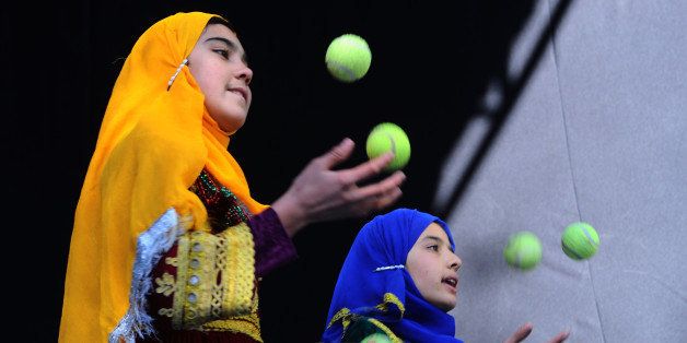 Afghan children from The Mobile Mini Circus for Children (MMCC) juggle during a circus show in Kabul on November 29, 2013. The Mobile Mini Circus for Children (MMCC) is an international non-profit NGO that has been working in Afghanistan since June 2002. The main objective of the MMCC is providing educational and informative entertainment for children, achieved by identifying, training, and applying the Afghan children's talents and potentials. AFP PHOTO .AFP/PHOTO Aref KARIMI (Photo credit should read Aref Karimi/AFP/Getty Images)