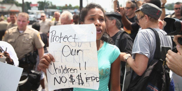 FERGUSON, MO - AUGUST 18: Demonstrators continue to protest the killing of teenager Michael Brown on August 18, 2014 in Ferguson, Missouri. After a protest yesterday ended with a barrage of tear gas and gunfire, Missouri Governor Jay Nixon activated the national guard to help with security. Brown was shot and killed by a Ferguson police officer on August 9. Despite the Brown family's continued call for peaceful demonstrations, violent protests have erupted nearly every night in Ferguson since his death. (Photo by Scott Olson/Getty Images)