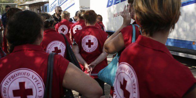 Employees of the Ukrainian Red Cross organization wait before checking on food and assistance products brought by the Ukrainian humanitarian convoy, on August 15, 2014 in the small eastern Ukrainian city of Starobilsk, Lugansk region. A spokesman for the Ukrainian government said on August 14 that 15 lorries would leave Kiev carrying around 240 tonnes of aid following a government pledge two days ago of roughly $750,000 (560,000 euros) in urgent assistance for the civilians living in insurgent-held territory. AFP PHOTO / ANATOLII STEPANOV (Photo credit should read ANATOLII STEPANOV/AFP/Getty Images)