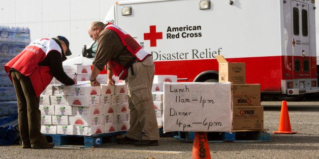 Volunteers with the American Red Cross review their notes as they distribute relief supplies to Hurricane Sandy victims November 5, 2012, in Ocean County, New Jersey. The Red Cross vans shuttle in food on 'search and feed' missions to victims in devastated costal areas. AFP PHOTO/Paul J. Richards (Photo credit should read PAUL J. RICHARDS/AFP/Getty Images)