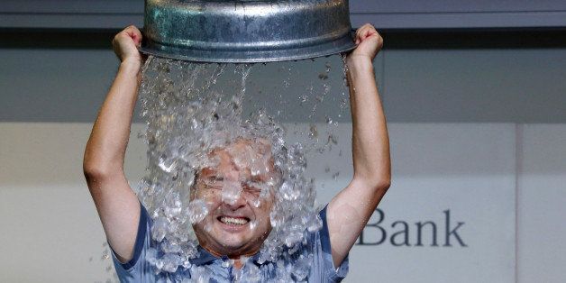 Billionaire Masayoshi Son, chairman and chief executive officer of SoftBank Corp., pours ice cubes over himself while taking part in the Ice Bucket Challenge to raise awareness for amyotrophic lateral sclerosis (ALS) in Tokyo, Japan, on Wednesday, Aug. 20, 2014. Son said after the event that he would 'cool his head and think' when asked about the company's next step following an effort to acquire T-Mobile US Inc. through Sprint Corp. Photographer: Tomohiro Ohsumi/Bloomberg via Getty Images 