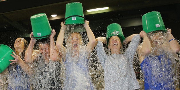 MELBOURNE, AUSTRALIA - AUGUST 22: Participants tip buckets of ice water over their heads as they take part in the World Record Ice Bucket Challenge at Etihad Stadium on August 22, 2014 in Melbourne, Australia. Over 700 people took part in setting the new world record. The Ice Bucket Challenge is the social media phenomenon which is helping raise awareness and money for sufferers of Motor Neurone Disease. (Photo by Scott Barbour/Getty Images)