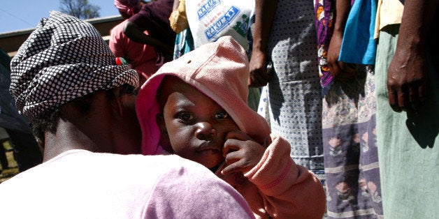 KENYA - JANUARY 07: A mother and child wait for food aid in the capital's Jamhuri Park, in Nairobi, Kenya, on Monday, Jan. 7, 2008. Kenya's opposition leader Raila Odinga called a rally in Nairobi tomorrow to protest last month's disputed election, as Ghana's President John Kufuor prepared to help mediate in the crisis. (Photo by Pieter Bauermeister/Bloomberg via Getty Images)