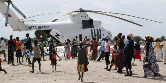 TO GO WITH AFP STORY BY PETER MARTELL Food aid is offloaded from a United Nations helicopter in the southern Sudanese town of