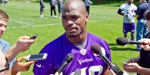 Minnesota Vikings running back Adrian Peterson (28) talks with reporters at the end of an NFL organized team activity at the Vikings football practice facility in Eden Prairie, Minn., Thursday, May 29, 2014.(AP Photo/Andy Clayton-King)