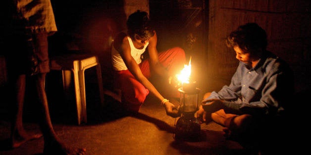 TO GO WITH Lifestyle-India-economy-energy by N. Suresh Indian men light up a kerosene petromax lamp in their home in the tribal hamlet of Wada, in Thane on the outskirts of Mumbai on November 18, 2007. An estimated 400 million Indians live in a world outside electricity. As India has grown, power generation has badly lagged with the gap between electricity supply and demand nationwide averaging up to 14 percent at peak times. AFP PHOTO / Pal PILLAI (Photo credit should read PAL PILLAI/AFP/Getty Images)