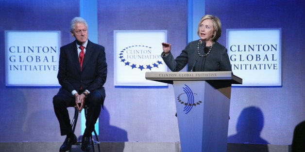 NEW YORK, NY - SEPTEMBER 22: Former U.S. Secretary of State Hillary Clinton (R) speaks as former U.S. President Bill Clinton looks on during the opening plenary session of the Clinton Global Initiative (CGI), on September 22, 2014 in New York City. The annual meeting, established in 2005 by President Bill Clinton, convenes global leaders to discuss solutions to world problems. (Photo by John Moore/Getty Images)