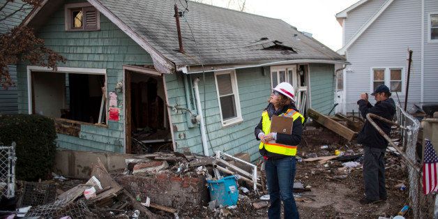 NEW YORK, NY - NOVEMBER 28: A woman with the Army Corps of Engineers and a representative from FEMA document a destroyed home November 28, 2012 in a residential area of New Dorp Beach in the Staten Island borough of New York City. Parts of the New Dorp Beach neighborhood were submerged under 10 feet of water during the height of Superstorm Sandy one month ago. (Photo by Robert Nickelsberg/Getty Images)