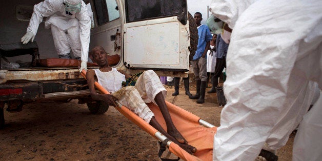 In this photo taken on Wednesday, Sept. 24, 2014, healthcare workers load a man suspected of suffering from the Ebola virus o