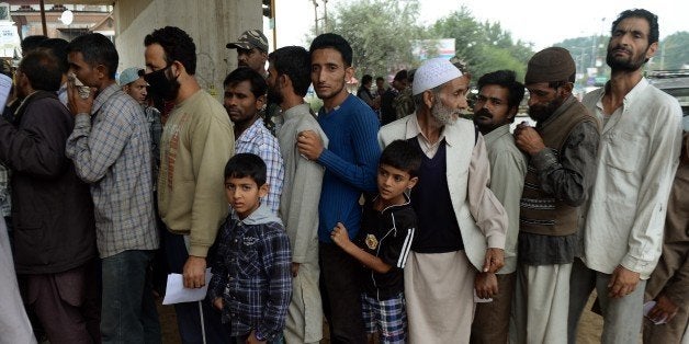 Flood-affected Kashmiris wait in line to meet Indian armed forces doctors at a temporary medical camp established underneath a flyover in Srinagar on September 12, 2014. The main city in Indian Kashmir has 'drowned completely' under floodwaters, a senior official said, with the deadly inundation now affecting about two million people in neighbouring Pakistan and threatening its all-important cotton industry. AFP PHOTO/ PUNIT PARANJPE (Photo credit should read PUNIT PARANJPE/AFP/Getty Images)