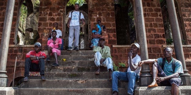 Volunteers, who are supposed to pick up bodies of people who died of the Ebola virus, against a 100 US dollar risk-taking compensation strike on October 8, 2014 in front of the abandoned Freetown university to get their salaries. Most of the other volunteers have gone back to work without receiving compensation. Dozens of British military personnel are due to fly to Sierra Leone next week to help build medical facilities to combat the Ebola epidemic, the defence ministry said on October 7. AFP PHOTO/FLORIAN PLAUCHEUR (Photo credit should read FLORIAN PLAUCHEUR/AFP/Getty Images)