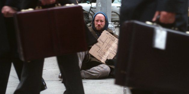 Jan Goldstein holds a sign expressing holiday good cheer and his need for food and shelter along 6th Avenue in New York Friday, Dec. 15, 1995. The stock market is soaring, and the rich are shopping, but barred from panhandling in the subway or squeegeeing in the streets, the poor are turning to their last resort. (AP Photo/Adam Nadel)