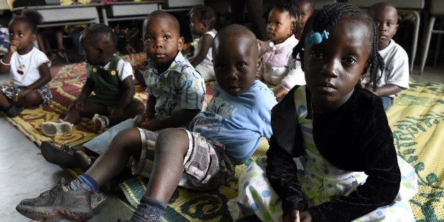 Children stand in a nursery while their parents are gone to church on September 28, 2014 in Monrovia. Liberia, the hardest-hit nation, has seen 3,000 cases of Ebola and almost 1,600 deaths, with health workers turning people away from treatment units due to chronic shortages of beds and staff. The country has some 150 foreign specialised medical workers on the ground but the UN has said they need at least 600, and health authorities are aiming to scale its current 400 Ebola beds up to around 2,000 within weeks. AFP PHOTO / PASCAL GUYOT (Photo credit should read PASCAL GUYOT/AFP/Getty Images)