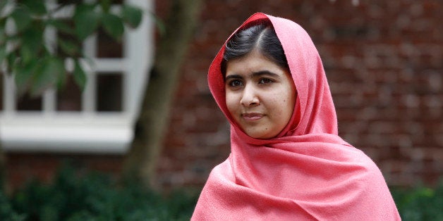 FILE - In this Friday, Sept. 27, 2013 file photo, Malala Yousafzai listens as Harvard President Drew Gilpin Faust introduces her to reporters at Harvard University in Cambridge, Mass. Yousafzai, who survived being shot by the Taliban because she advocated education for girls, has been named the National Constitution Center's Liberty Medal recipient and is scheduled to receive the award at a ceremony on Oct. 21, 2014, in Philadelphia. (AP Photo/Jessica Rinaldi, File)