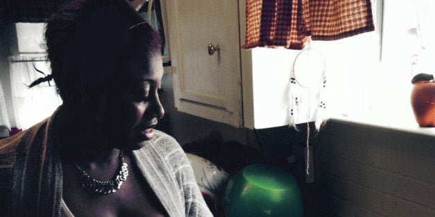 FILE- In this Aug. 26, 2014 file photo, Sherita Melton, runs water in her kitchen after water service was restored after reac