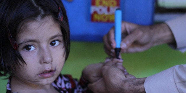 LAHORE, PUNJAB, PAKISTAN - 2014/09/29: A Pakistani Health worker administers polio drops to children during the 3-days special anti-polio campaign launched by the Provincial Government at the Railway station in Lahore. Since the start of the first National Immunization Days (NIDs) in the early 1990s, Pakistan has made great progress towards eradicating polio from the country. Through heroic efforts of front line health workers and concerted focus by the Government of Pakistan, the number of polio cases in Pakistan has dropped from a high of more than 30,000 cases a year when the program started, to only 58 in 2012. (Photo by Rana Sajid Hussain/Pacific Press/LightRocket via Getty Images)