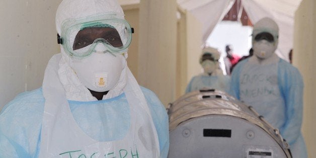 Kenyan medical worker from the Infection Prevention and Control unit wearing full protective equipment show on October 28, 2014, how to handle an infected Ebola patient on a portable negative pressure bed at the Kenyatta national hospital in Nairobi. Measures have been put in place ahead of the arrival of the 12 Kenyans returning from Ebola-hit Liberia. Health officials battling the Ebola outbreak that has killed more than 4,500 people in West Africa have managed to limit its spread on the continent to five countries, with Kenya so far escaping the virus. AFP PHOTO / SIMON MAINA (Photo credit should read SIMON MAINA/AFP/Getty Images)