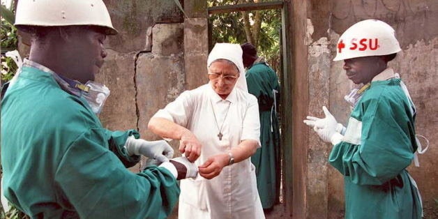 KIKWIT, ZAIRE: An Italian nun (C) helps two Zairean health workers remove their surgical gloves 13 May at a hospital in Kikwit, the area at the center of the deadly Ebola virus epidemic. The first truckloads of food from this southwestern Zairean town, arrived in Kinshasa, 21 May, after authorities lifted roadblocks sealing off the region. AFP PHOTO (Photo credit should read CHRISTOPHE SIMON/AFP/Getty Images)