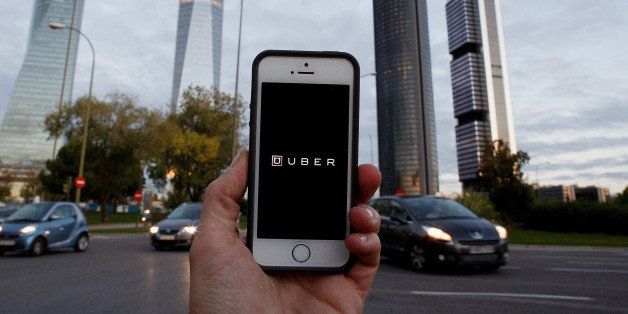 MADRID, SPAIN - OCTOBER 14: In this Photo Illustration a smart phone displays a picture with the logo of the news taxi app 'Uber' near the Cuatro Torres 'Four Towers' business area on October 14, 2014 in Madrid, Spain. 'Uber' application started to operate in Madrid last September despite Taxi drivers claim it is an illegal activity and its drivers currently operate without a license. 'Uber' is an American based company which is quickly expanding to some of the main cities from around the world. (Photo Illustration by Pablo Blazquez Dominguez/Getty Images)