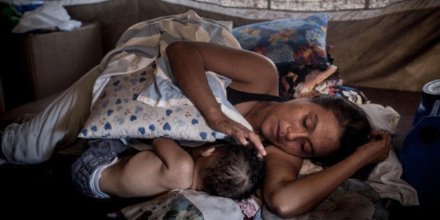 TACLOBAN, LEYTE, PHILIPPINES - NOVEMBER 06: Jessica Flores Vevera sleeps with her baby in her tent on November 6, 2014 in San Jose, Tacloban, Leyte, Philippines. Residents of Leyte are preparing for the 1-year anniversary since Super Typhoon Yolanda struck the coast on November 8, 2013, leaving more than 6000 dead and many more homeless. (Photo by Chris McGrath/Getty Images)