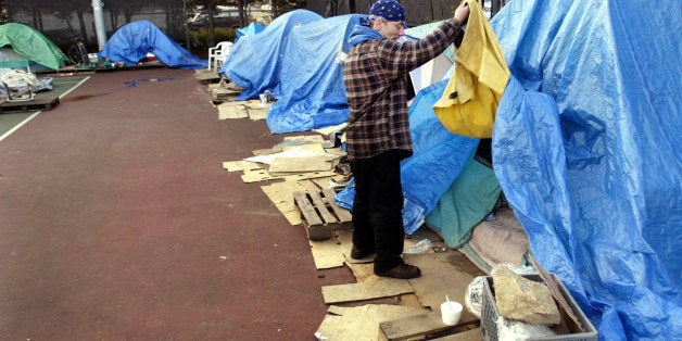 Nick Poland, a resident of Tent City 3, which is located until the end of February on the tennis courts at Seattle University, opens the front door of his home, the tarp-reinforced tent that he shares with his wife, Thursday, Feb. 10, 2005 in Seattle. One of the big draws of the self-governed homeless community is that couples can live together -- they can't in most shelters -- and the camp offers in-and-out privileges day or night, which allows Poland to sell copies of "Real Change," a newspaper published and written by homeless advocates, during the busy evening and night hours outside a nearby grocery store. (AP Photo/Ted S. Warren)