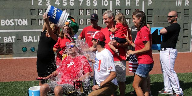 BOSTON - AUGUST 14: Julie Frates, wife of Peter Frates, former Boston College baseball captain who has ALS and is behind the ice bucket challenge that has gone viral, dumps a bucket of ice water on her husband in a brief on field ceremony where Frates issued a challenge to President Obama and two others. Family members John and Nancy Frates, parents, Brother Andrew, sister Jennifer Mayo, niece Adelyn, 2, Boston Red Sox manager John John Farrell, catcher David Ross, Will Middlebrooks, and Dustin Pedroia also joined Frates on the field. (Photo by Barry Chin/The Boston Globe via Getty Images)