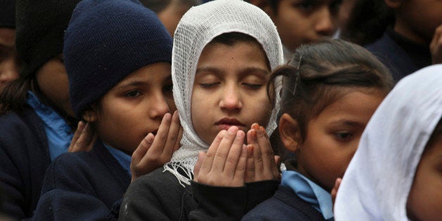 Pakistani students pray during a special ceremony for the victims of Tuesday's school attack in Peshawar, at a school in Laho