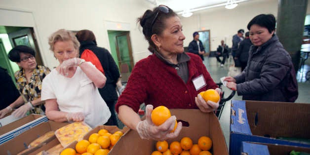 Volunteer Caroline Osterman, center, of Boston, distributes oranges in the Franciscan Food Center food pantry at St. Anthony Shrine in Boston, Thursday, March 29, 2012. The Franciscan Food Center, which is mainly staffed by volunteers, was founded in 2008 and distributes food to about 1300 people weekly. (AP Photo/Michael Dwyer)