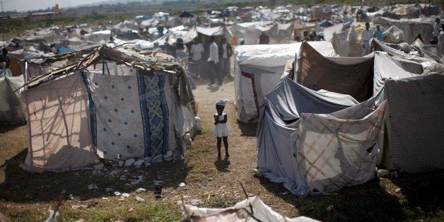 FILE - This Feb. 13, 2010, file photo shows a child standing among makeshift tents at a refugee camp for earthquake survivors in the Cite Soleil neighborhood of Port-au-Prince. A few hours before 19-year-old Britney Gengel was buried alive in the earthquake, she texted her parents her last dream: "I want to move here and start an orphanage." Nearly five years later Gengel's father is fulfilling the dream of his late daughter. (AP Photo/Rodrigo Abd, File)