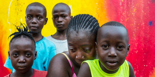 MONROVIA, LIBERIA - NOVEMBER 11: Deedee Urey whose husband and 4 month old baby died in September of Ebola, cries as she poses with her four surviving children on Tuesday November 11, 2014 in Monrovia, Liberia. The Urey family pictured are (front row) Miatta Urey, 6, Jimboy, 4, Deedee Urey, Prince, 15, back left, Francis, 10, back right. The family lived in one room where Deedee cared for her Ebola infected husband and child. Deedee and the four children succumbed to Ebola but survived after care at the Island Ebola Treatment Unit. Now perplexed about what the future holds; she now is a house cleaner, only twice per week to support her four other children. (Photo by Michel du Cille/The Washington Post via Getty Images)