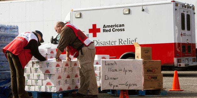 Volunteers with the American Red Cross review their notes as they distribute relief supplies to Hurricane Sandy victims November 5, 2012, in Ocean County, New Jersey. The Red Cross vans shuttle in food on 'search and feed' missions to victims in devastated costal areas. AFP PHOTO/Paul J. Richards (Photo credit should read PAUL J. RICHARDS/AFP/Getty Images)