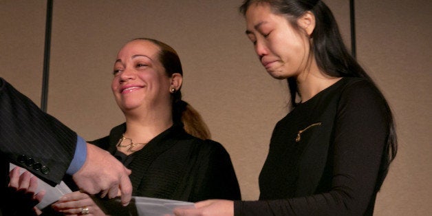 Maritza Ramos, left, and Pei Xia Chen, widows of slain New York City Police Officers Rafael Ramos and Wenjian Liu, receive checks from the Stephen Siller Tunnel to Towers Foundation, Wednesday, Jan. 7, 2015, in New York. The foundation says $860,000 has been donated and another $150,000 has been pledged to pay off the mortgages of Officers Liu and Ramos, who were killed in December while on duty in Brooklyn. (AP Photo/Richard Drew)