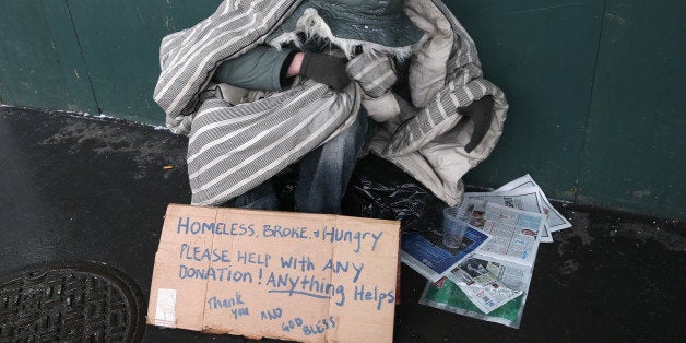 NEW YORK, NY - JANUARY 21: A homeless person bundles against the cold during a snowstorm on January 21, 2014 in New York City. Areas of the Northeast are predicted to receive up to a foot of snow in what may be the biggest snowfall of the season so far. (Photo by John Moore/Getty Images)